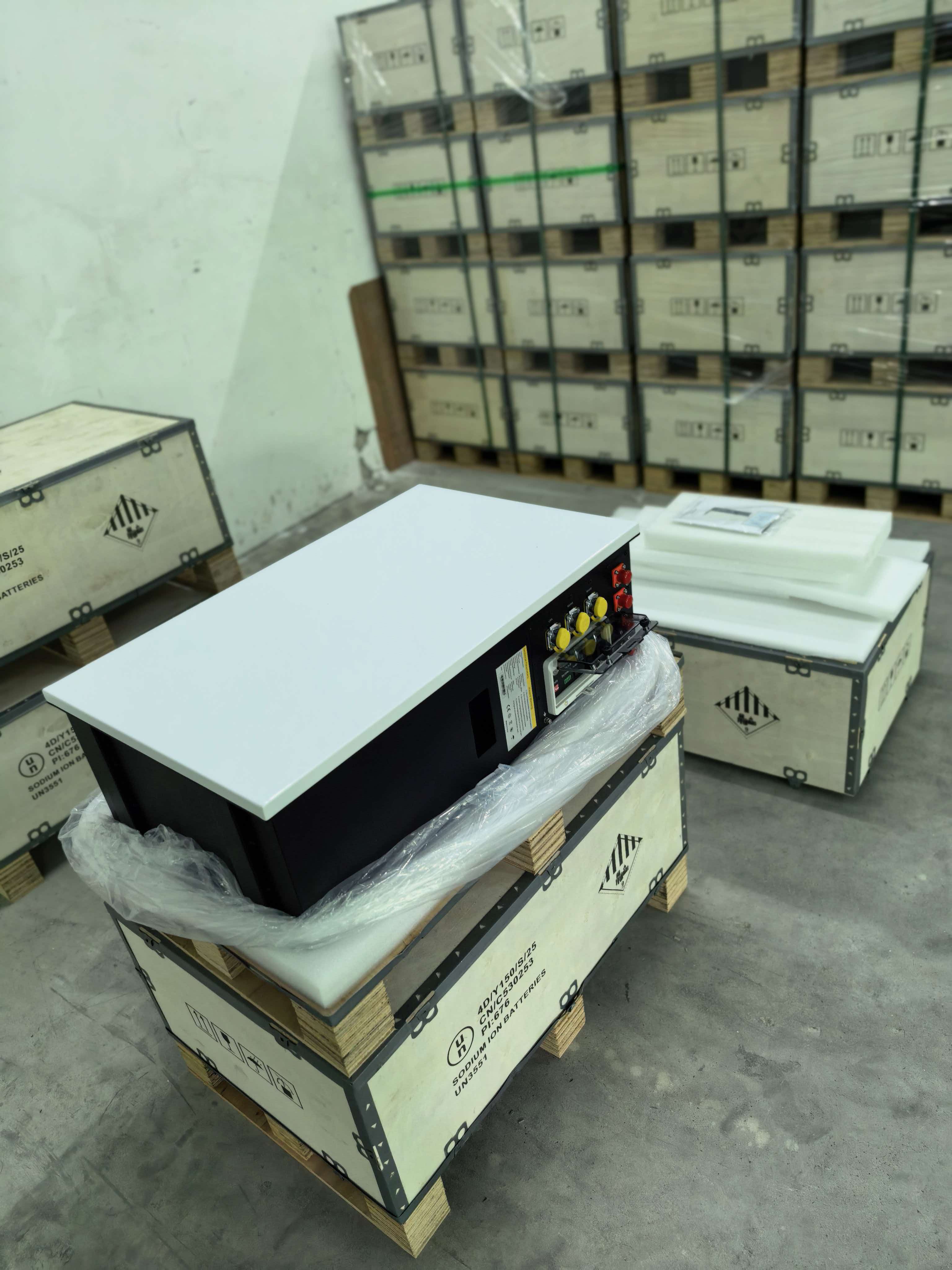 AuroraCell residential energy storage battery unpacked beside shipping crates in the warehouse